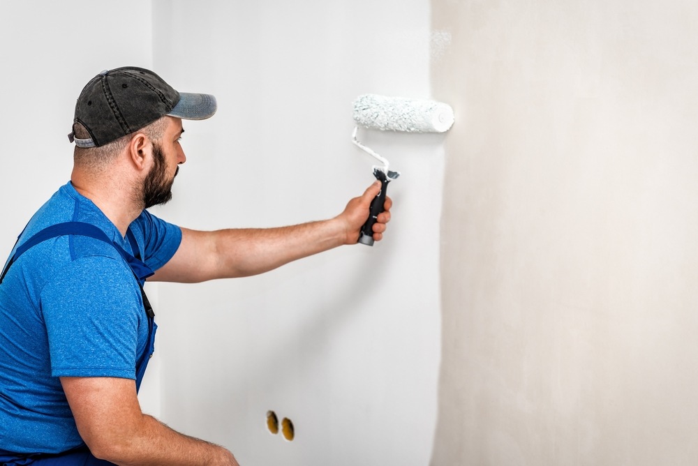 Técnico de Prohucon pintando la pared tras un problema de condensación en Madrid 